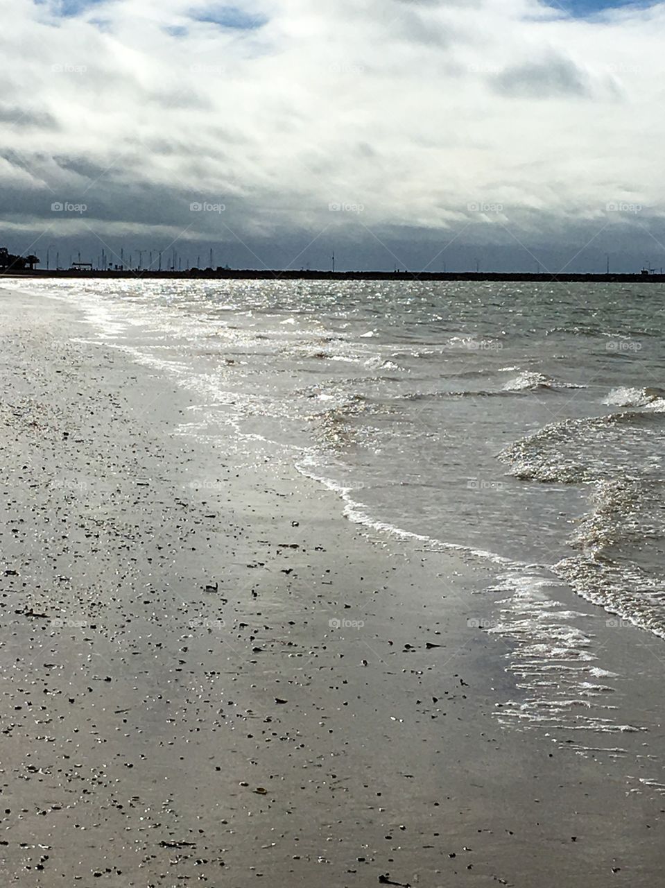 Stormy day at the ocean, here the sand, water, sparkles in the strange light cast by the dark clouds in Spence's gulf on the eyre peninsula in south Australia   Perfect for a background image