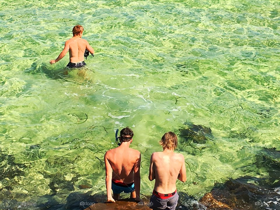 Youth climbing rocks Oceanside south Australia 