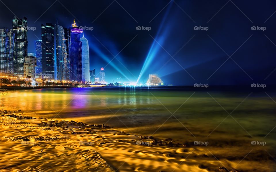 Illuminated buildings near sea coast