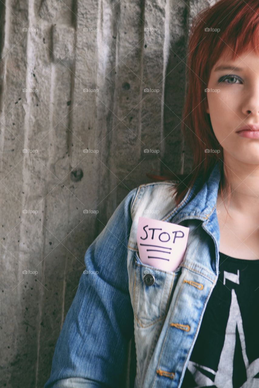 Girl dressed in denim with a stop written note in her pocket