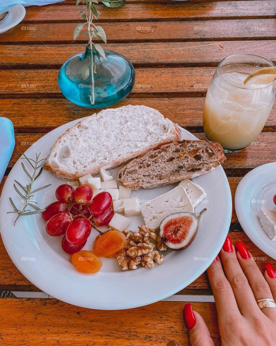Grapes, apricots, bread, cheese, nuts and juice.