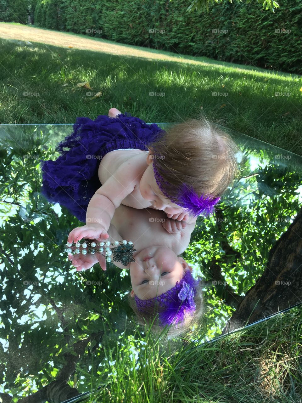 Baby playing on a mirror