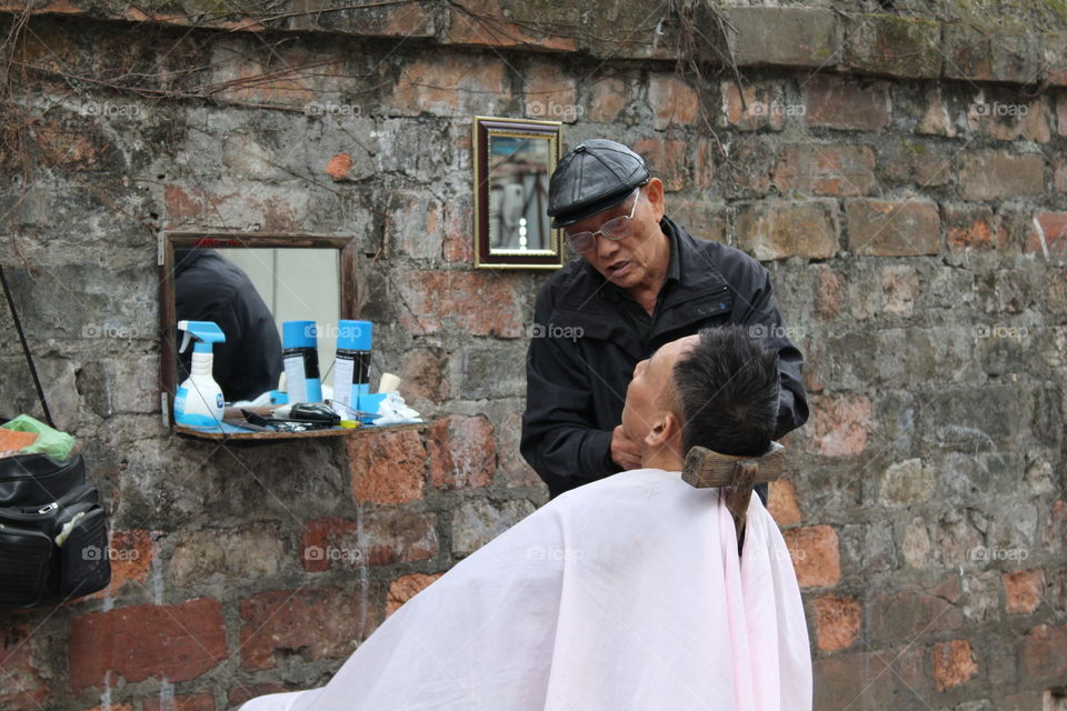 Shaving on street in Hanoi