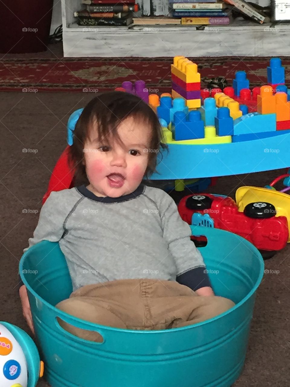 Baby sitting in the bin he emptied out of his toys!
