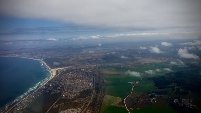 A bird’s view of the Earth. On a plane flying over the ocean close to landing 