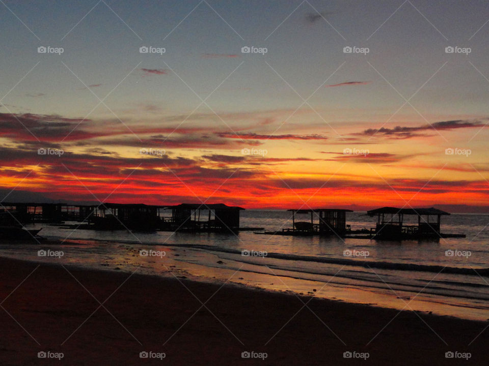 Scenic view of beach against sky at sunset 