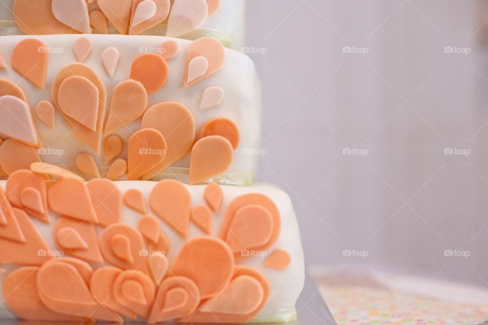 Horizontal image of wedding cake with pastel orange petals