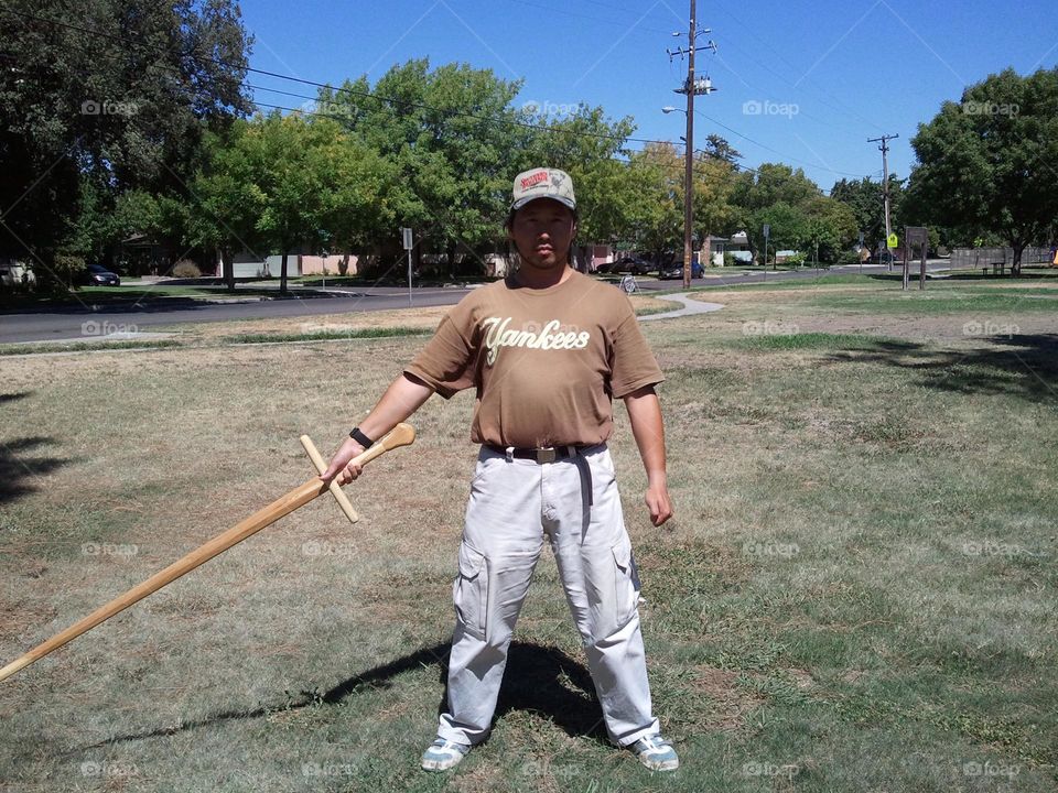 Standing in a natural posture with a waster. Exercising with a wooden sword at the park on a nice day during the weekend provides me with positive energy flow going through my body. Also, it is a departure from traditional workouts.