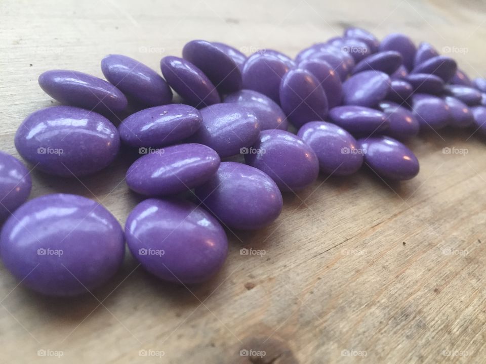 Purple candies on wood background 