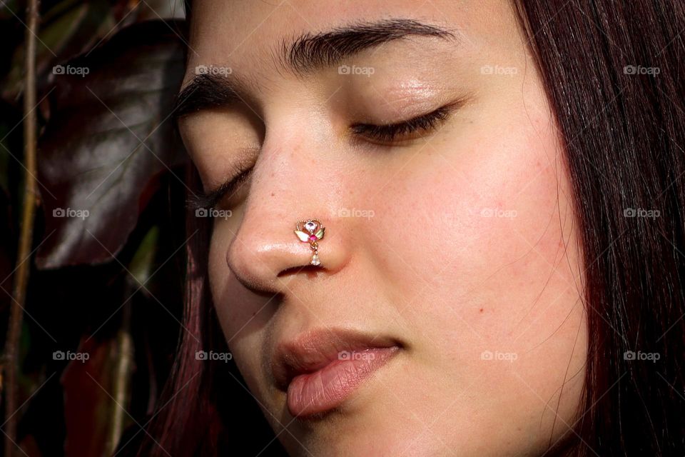 Gorgeous girl with golden jewellery in her pierced nostril