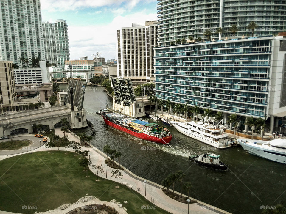 Tug and Ship on the Miami River. The contrast of industry and extravagance can be seen on the Miami River.
