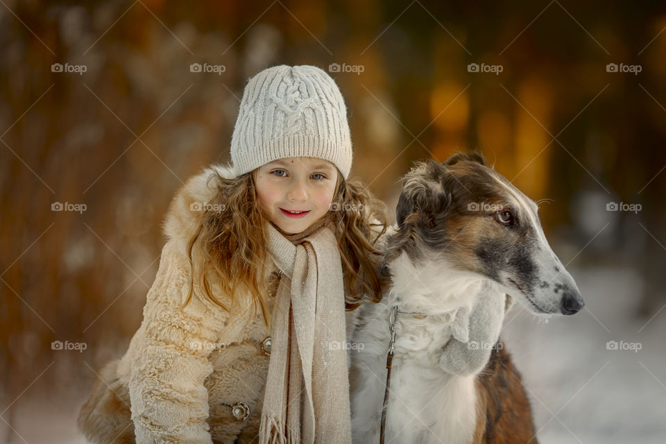 Little girl with dog in autumn park 