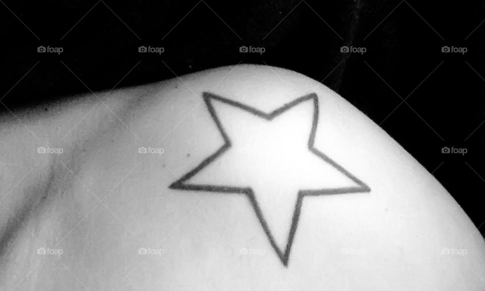 Woman's shoulder with star tattoo 