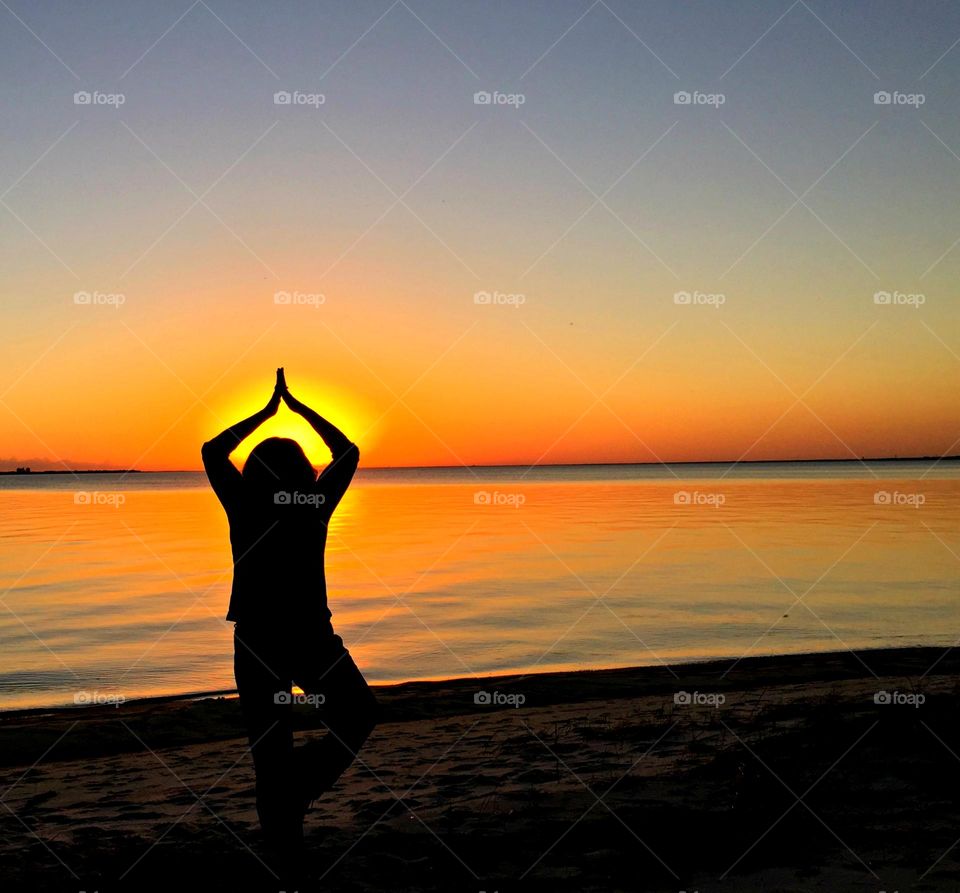 The Stillness Within - A young women performs Meditation on the beach at a magnificent sunrise