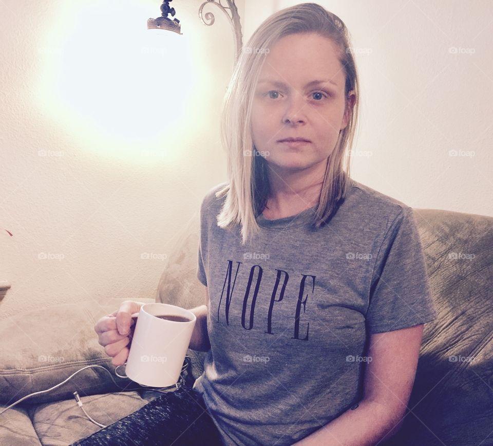 Woman sitting on sofa with holding cup of coffee