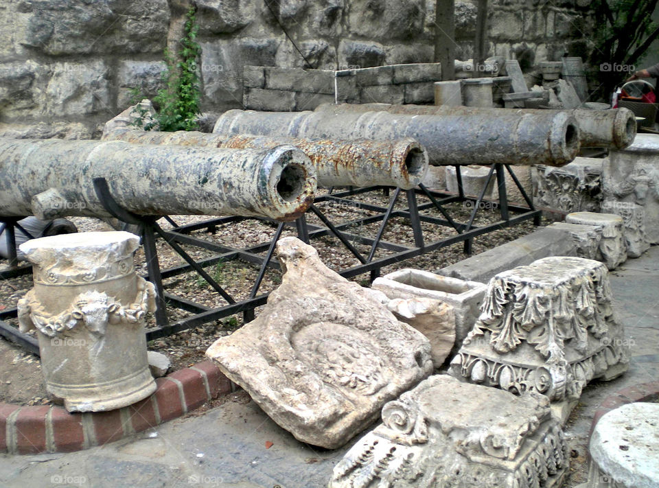 Antiques, an old cannons and stoned reliefs