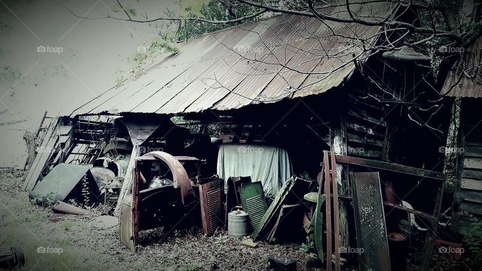 Forgotten shed with tools, car parts, and other forgotten things