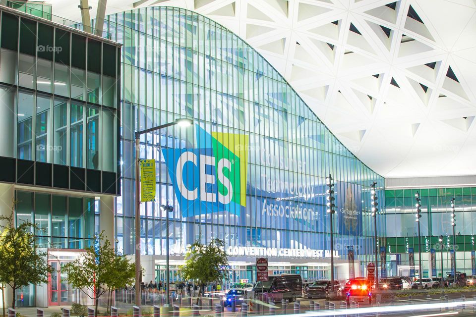 Las Vegas, NV, USA 1-6-2023: Exterior of Convention Center West Hall during CES2023. Logo of CES on glass wall. Light trails from car headlights of traffic passing by. Captured in long exposure.