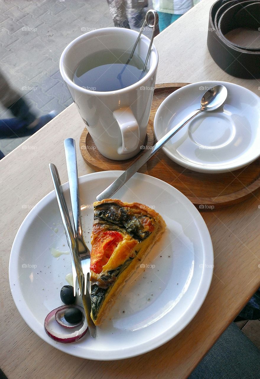 A slice of vegetable tart. A slice of vegetable tart with spinach and tomatoes