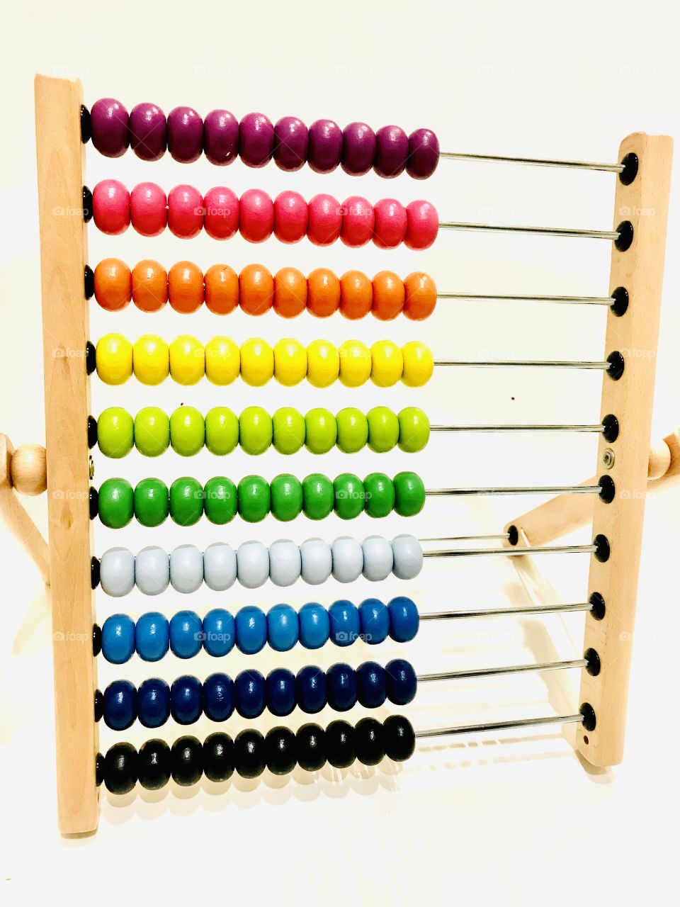 Gorgeous very colorful photo of rainbow colored abacus beads displayed against white background. 