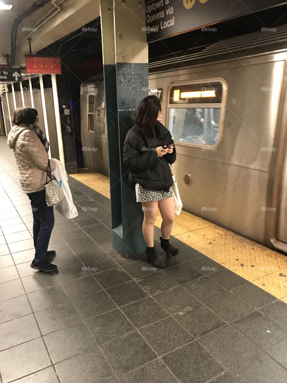 Beautiful girl in a miniskirt waits for the uptown Broadway local at Times Square Station.