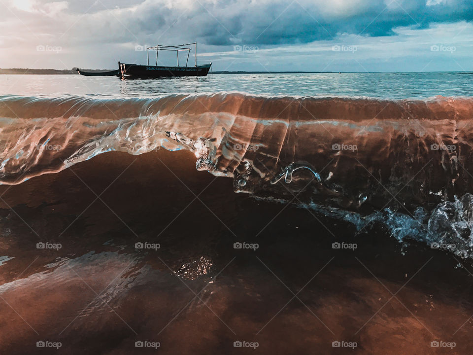 amazing this wave breaking and the boats behind it, the ocean is beautiful