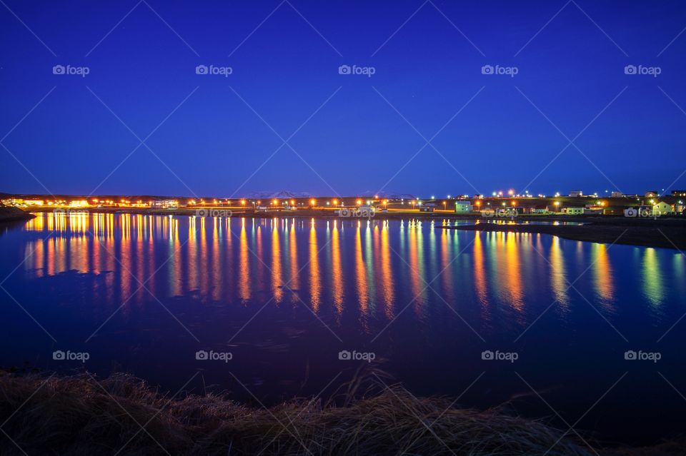 A colourful reflection of lights in a river of a Icelandic village