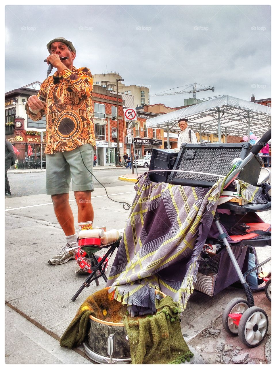 Mature man performing mouth organ music in city street