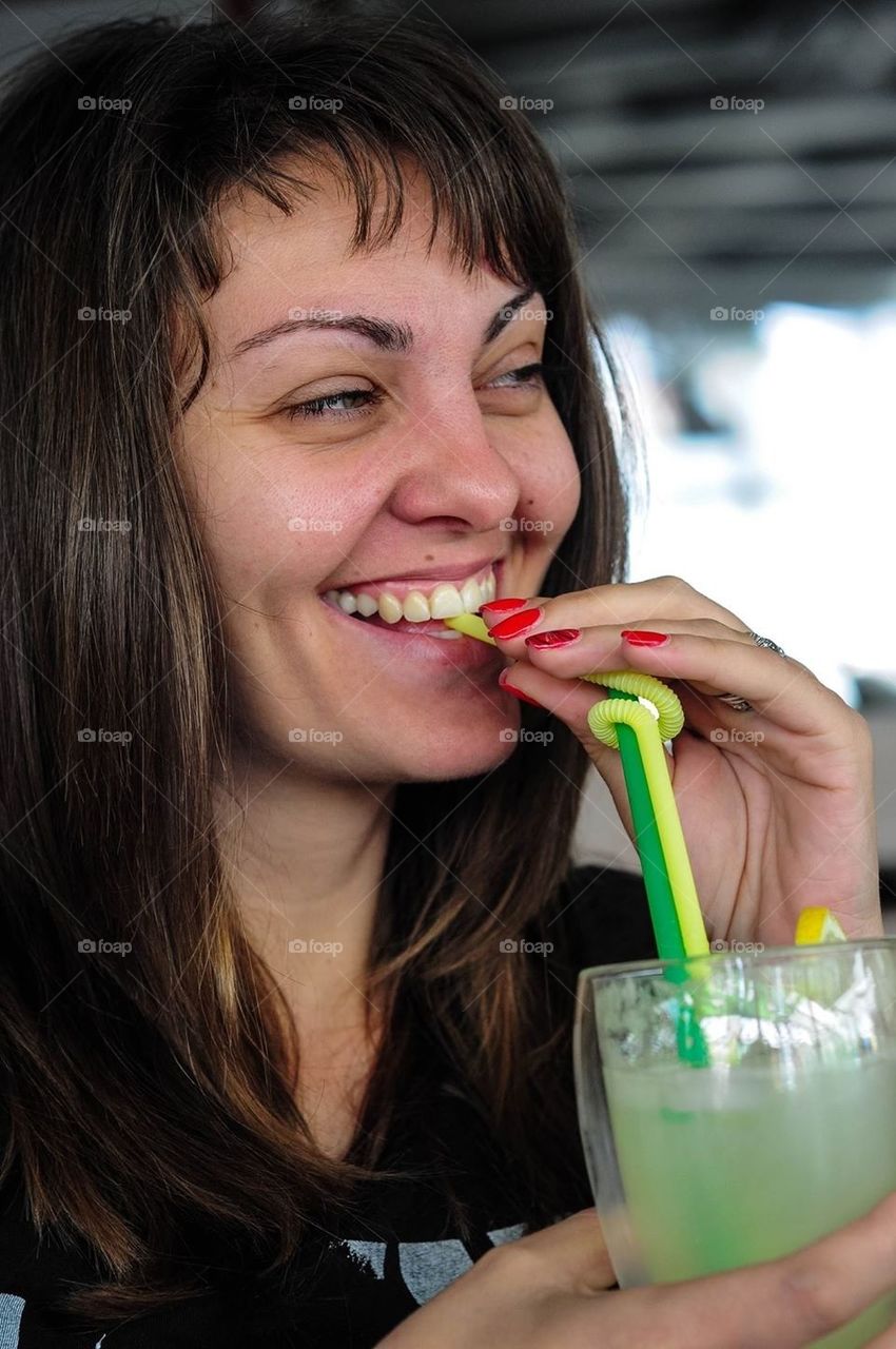 Smiling young woman drinking lemonade