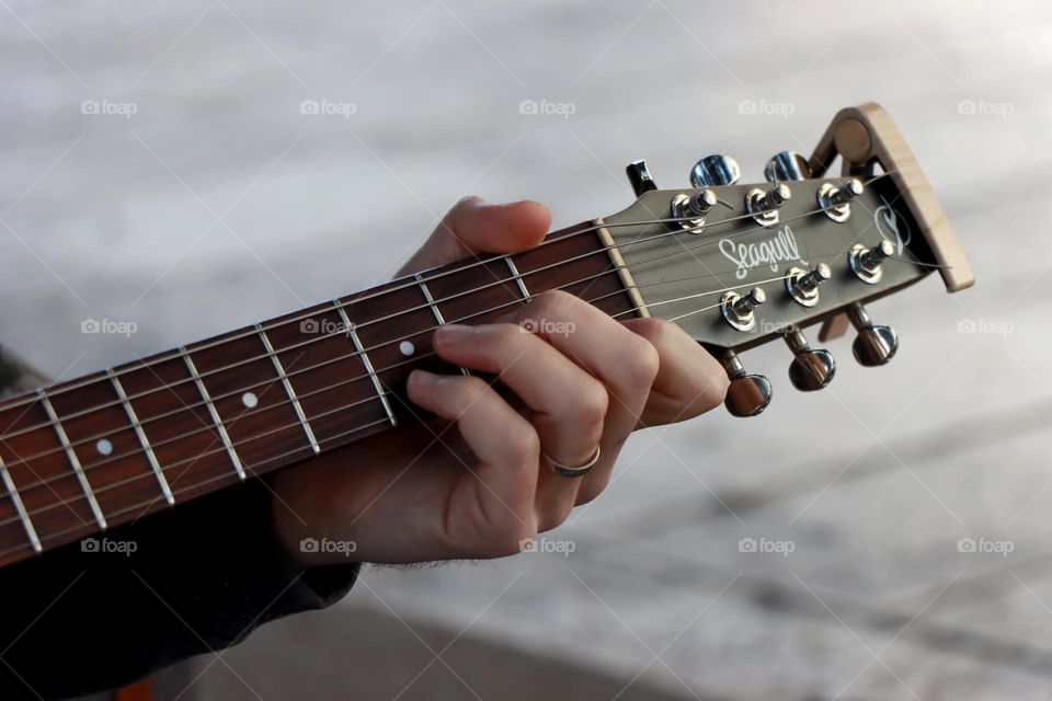 A musician fingers on guitar neck