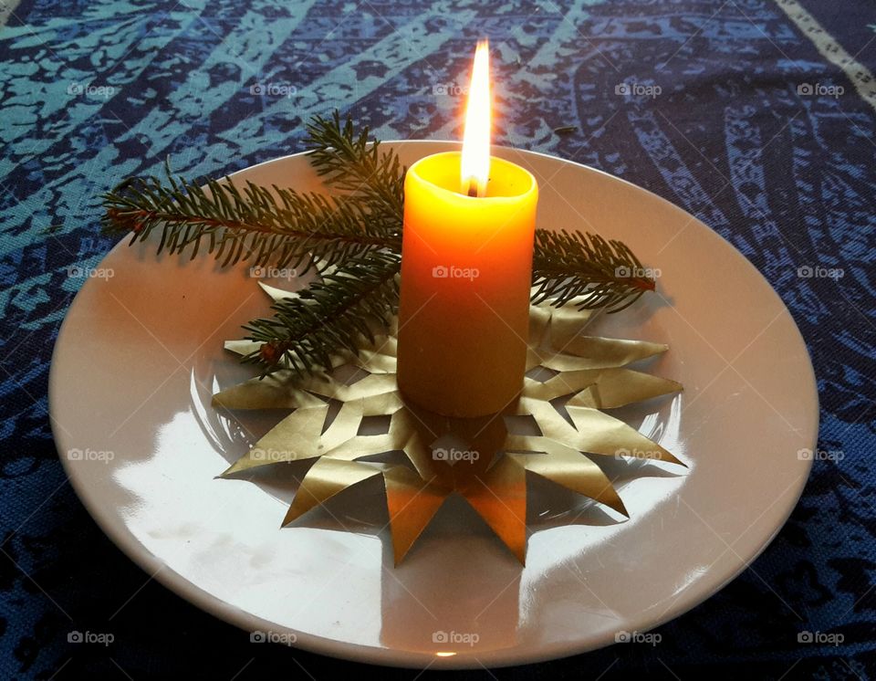 a burning advent candle on a table