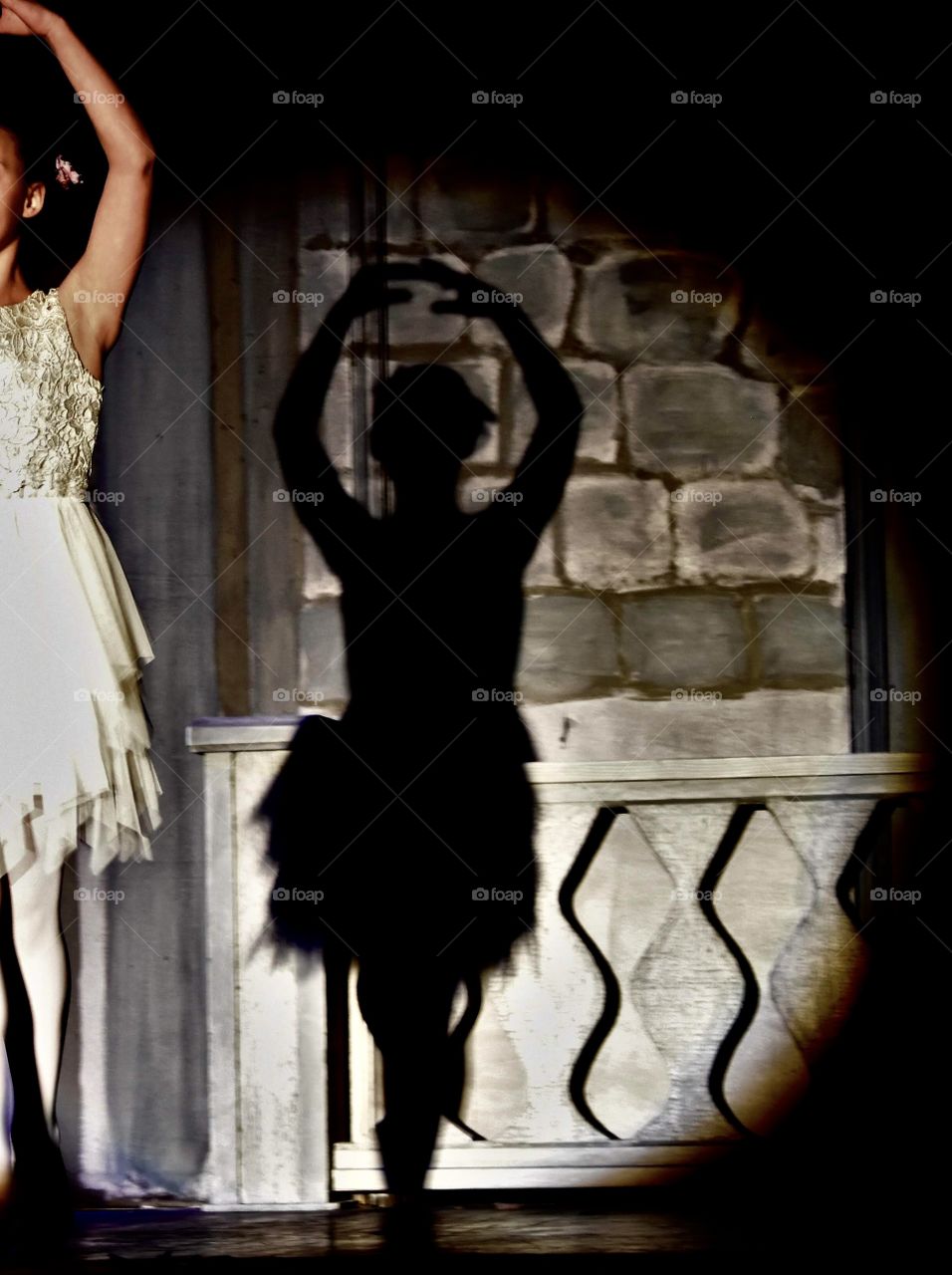 Ballerina and her shadow in the spotlight 