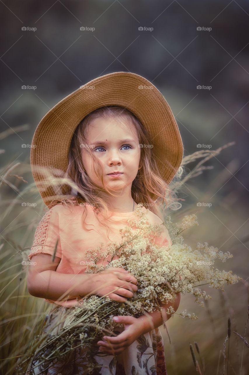 Little girl with bouquet of meadow flowers. 