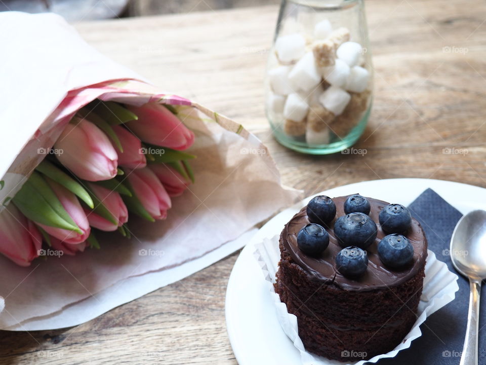 cupcake with blueberrys and tulips on the side