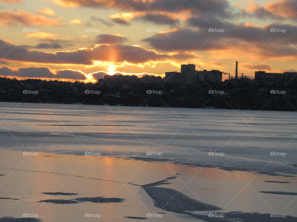 frosty evening in February, sunset and the sky in the clouds, I like to look at the sun going beyond the horizon in winter