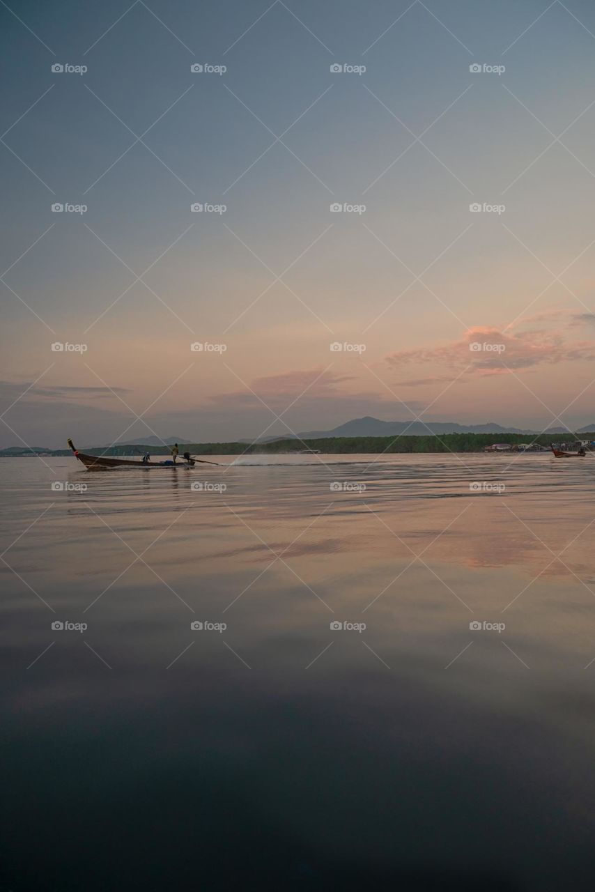 Beautiful Sunrise moment above silhouette of boat in sea