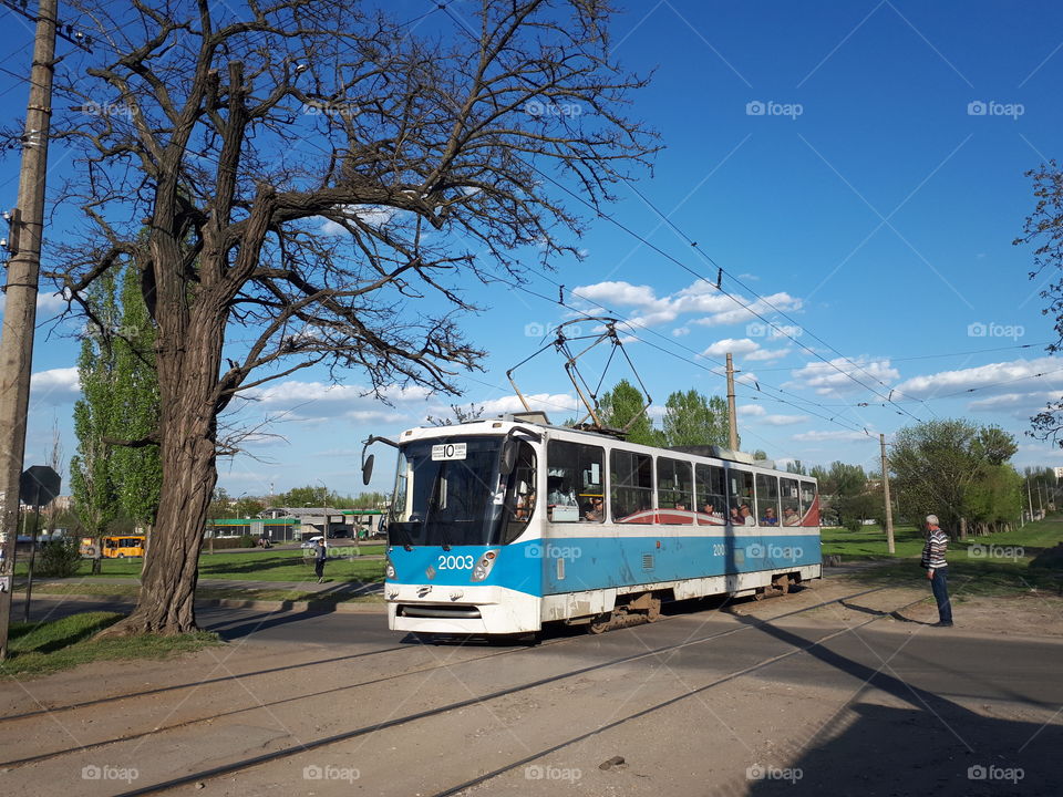 The blue tramway is riding down the street