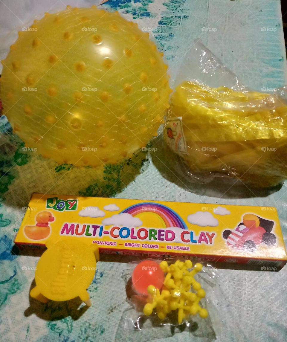 #COLOR:YELLOW,   THINGS THAT ARE YELLOW SUCH AS TOY TABLE, JACKSTONE, MULTI COLORED CLAY, TOY BALL AND TWINE