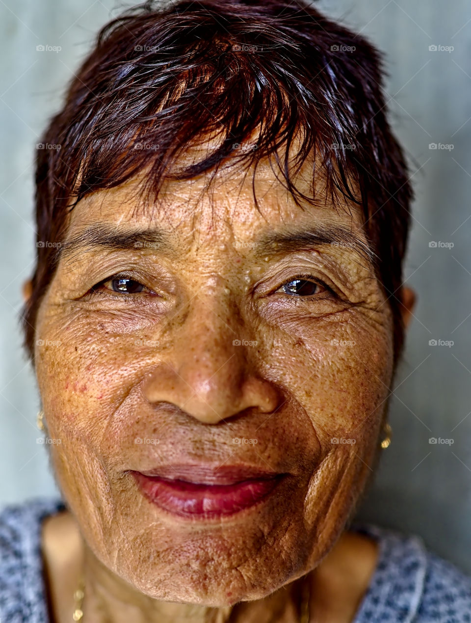 A smiling portrait of an old asian woman