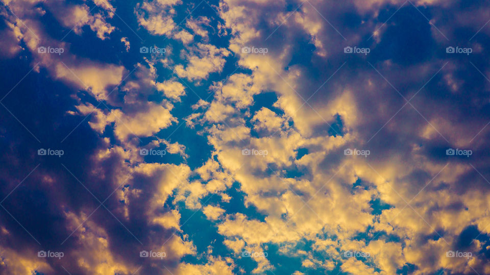 Large clouds float across the sunset sky like sails.