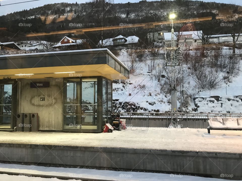 This is Voss train station in Norway. It’s an early morning picture, with a snowy peron. The station lights still hasn’t turned off, and shines up the train station before the sun rises.