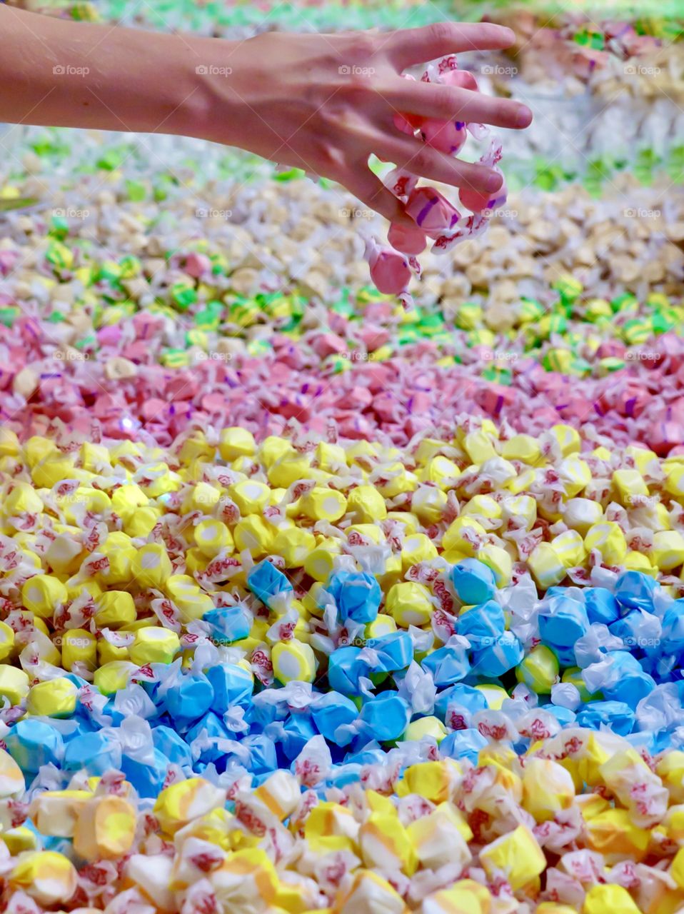 Grabbing a handful of saltwater taffy - rows of coloured candies 