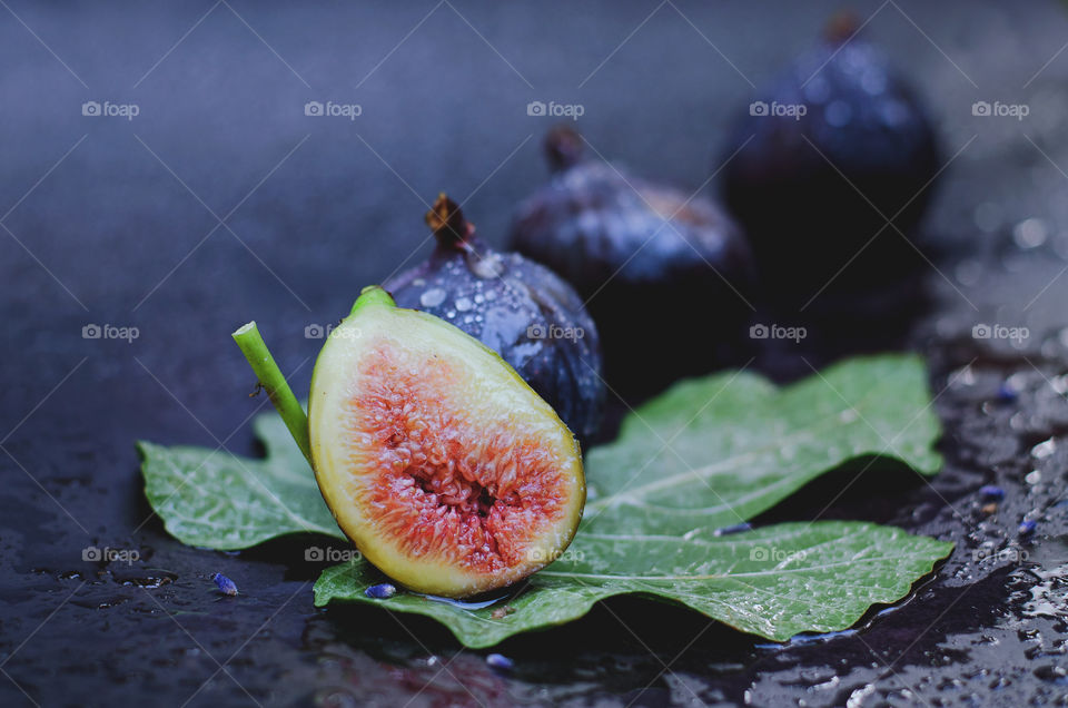 Top view of fresh ripe purple figs on black background close up. Flatlay. Food concept.