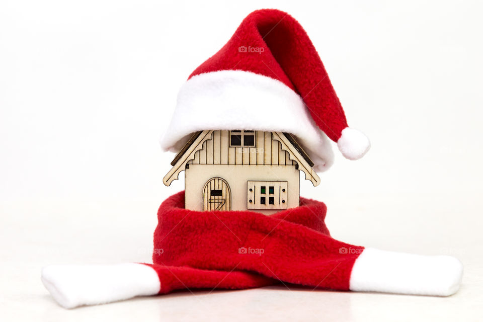 toy wooden house in a red cap Santa Claus and in red scarf on a white background