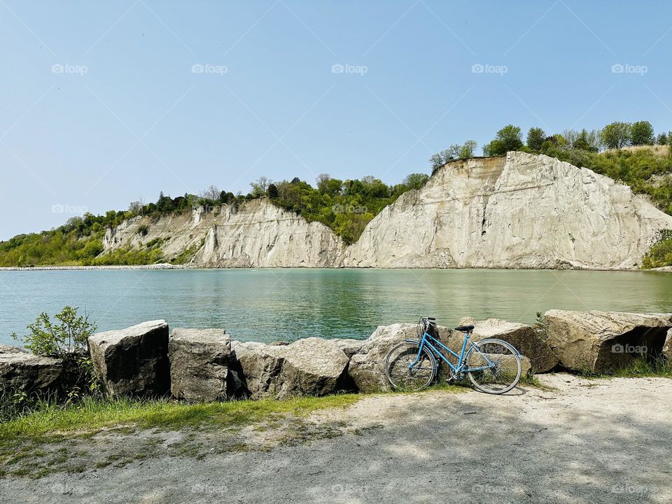 Lonely bicycle, bike standing near beautiful green Lake Ontario in sunny spring day.