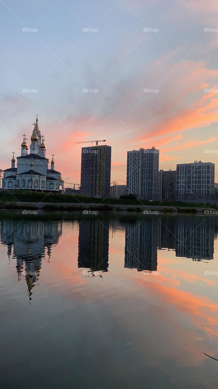 geometric shape square. Church and houses by the river. reflection