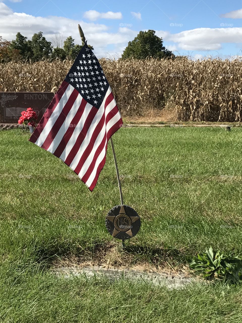 American flag and U.S. veteran marker at a gravesite.