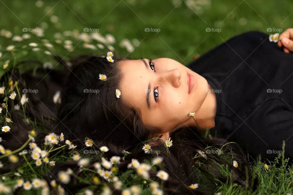 Beautiful girl in wildflowers. Spring time. Woman portrait. Girl whit long hair and wildflowers in her hair.