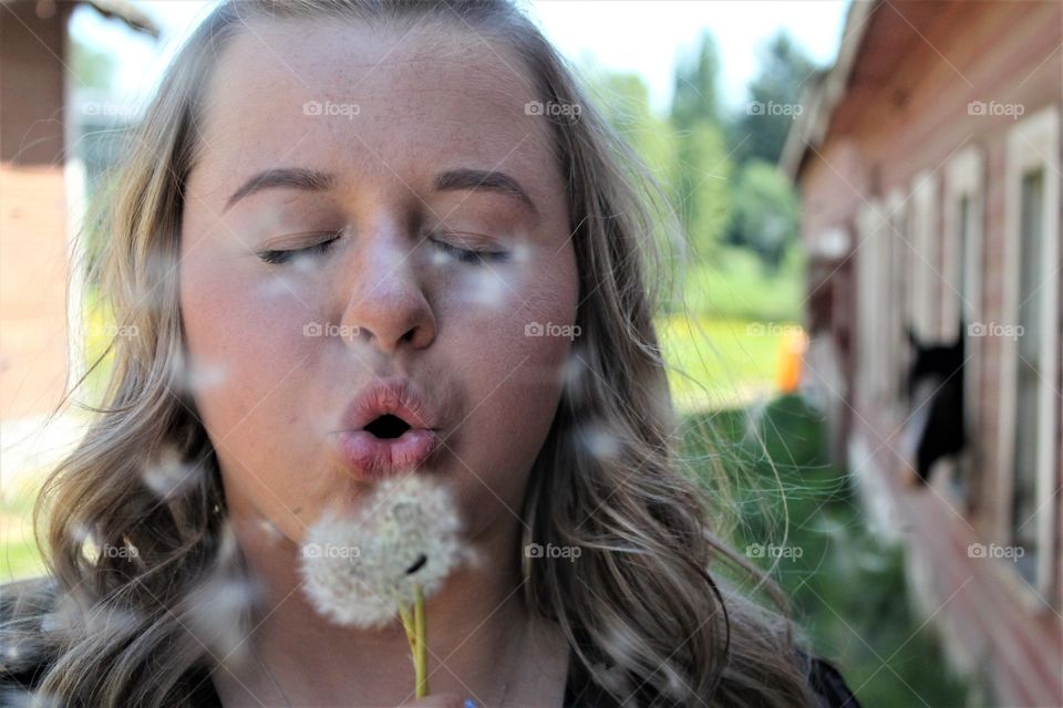 blowing a dandelion