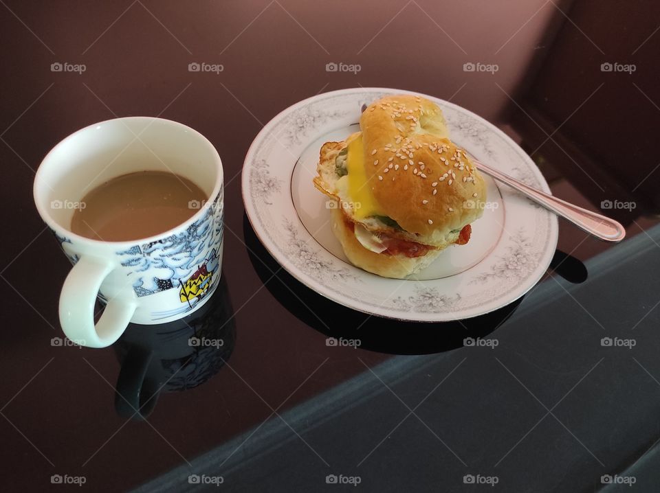 Morning breakfast with a cup of white coffee and a burger